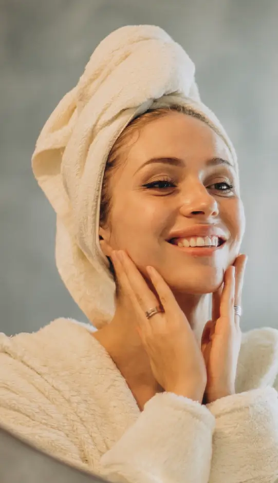 Une femme radieuse illustrant comment avoir un glow up grâce à la Solution Body Glow (Collagène ELASTICARE et Kératine KERAGENIC).